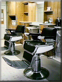 View inside the barber shop show the two barber chairs, back-bar and shampoo bowls